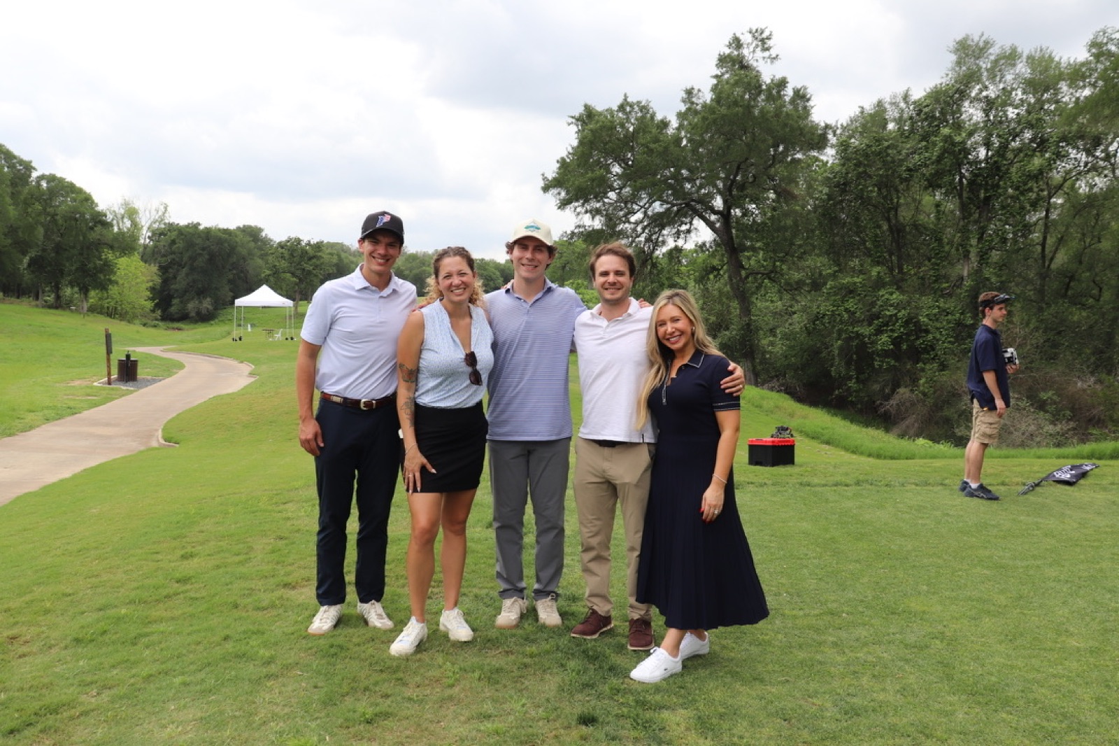 Cinco compañeros de equipo en el campo el día de golf de USLege