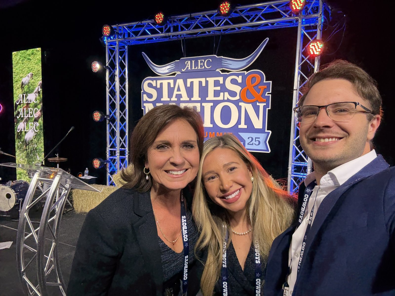 USLege team members posing in front of the ALEC States and Nation Policy Summit stage backdrop