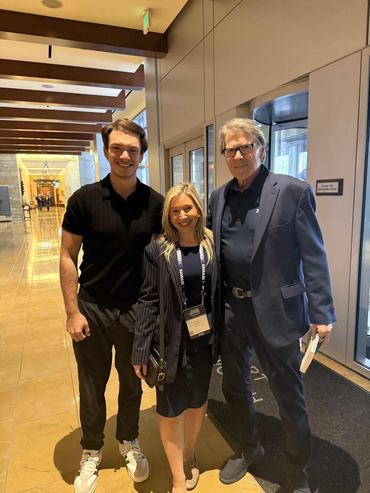 Three USLege team members posing together in the conference hotel lobby