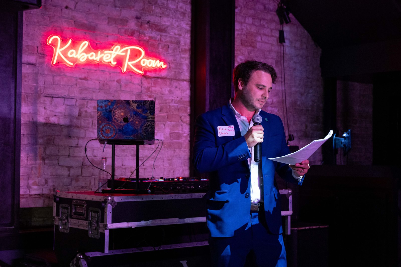 Eric Davis, USLege founder, speaking into a microphone on stage under a Kabaret Room neon sign