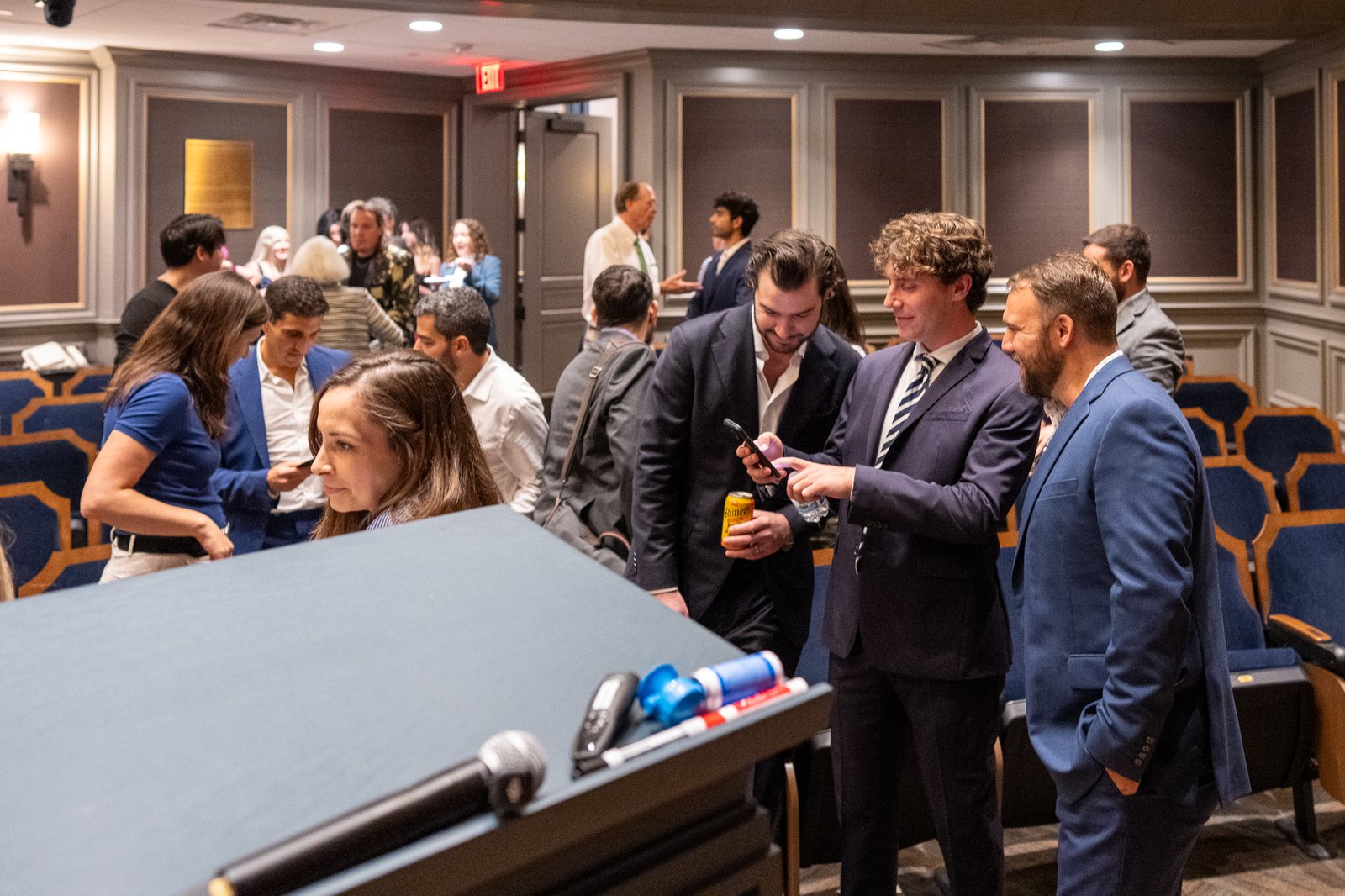 A group of guests networking near the registration area after the event