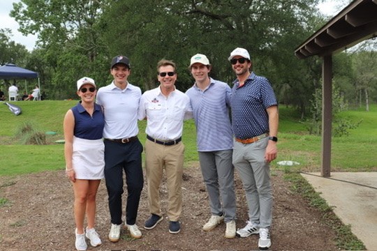 Five golfers posing together near the clubhouse at the Senate Republican Caucus Golf Tournament
